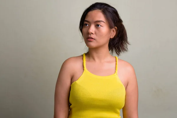 Joven hermosa mujer asiática usando amarillo sin mangas superior —  Fotos de Stock