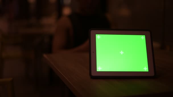 Tablette numérique avec écran vert contre jeune homme asiatique en arrière-plan — Video