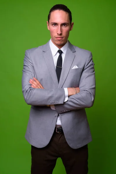 Joven hombre de negocios guapo contra fondo verde —  Fotos de Stock