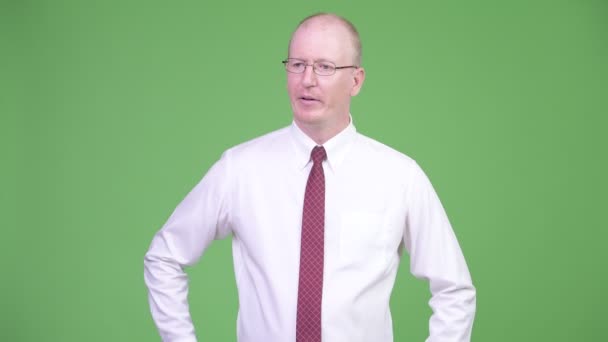 Mature bald businessman looking bored with arms crossed — Stock Video