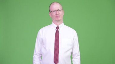 Stüdyo çekim gözlük chroma anahtar yeşil arka plana sahip karşı giyen olgun kel işadamı