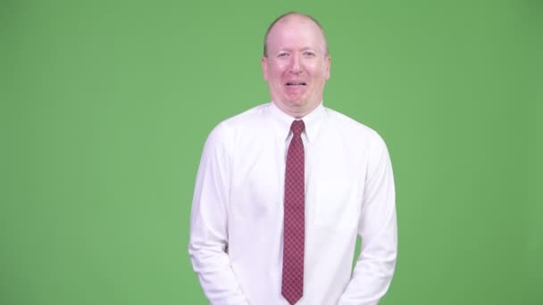 Happy mature bald businessman laughing while pointing at camera — Stock Video