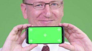 Telefon gösterilen süre gülümseyen mutlu olgun kel iş adamı