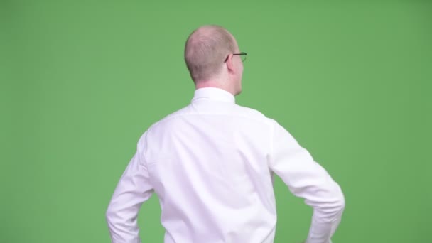 成熟したハゲ実業家ポインティング指の背面図 — ストック動画