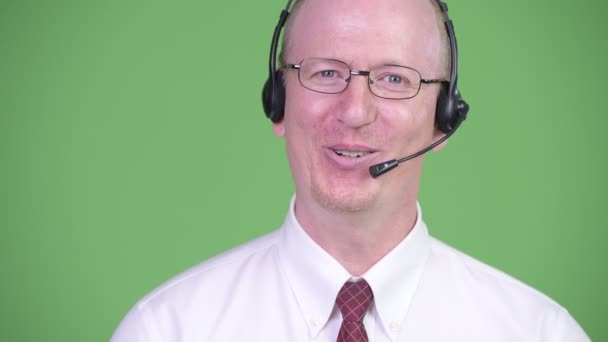 Happy mature bald businessman working as call center representative — Stock Video