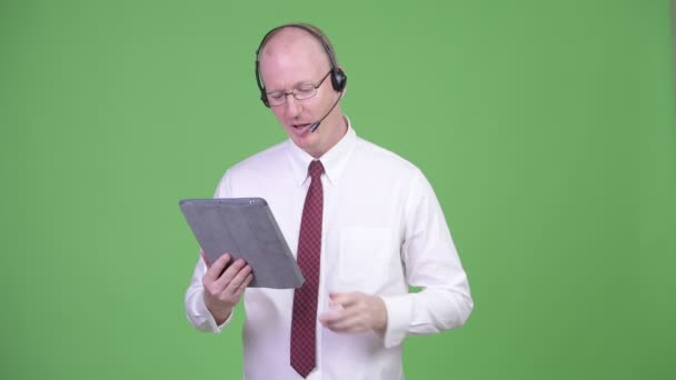 Glad mogen skallig affärsman arbetar som call center representant — Stockvideo