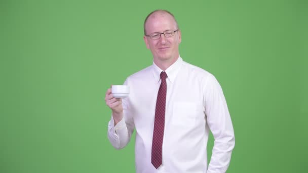 Mature bald businessman turning coffee cup upside down — Stock Video