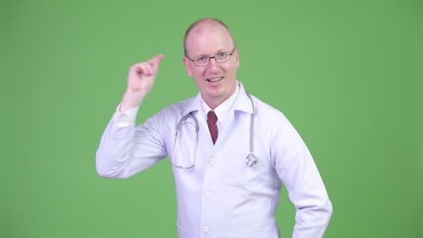 Szczęśliwy człowiek łysy dojrzałe Doktor przyciąganie palców i pokazując coś — Wideo stockowe