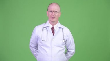 Bir şeyler açıklamaya kameraya konuşurken olgun kel adam doktor