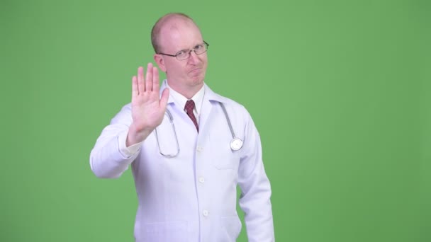 Зрілий лисий чоловік лікар зі стоп-рукою жестом — стокове відео