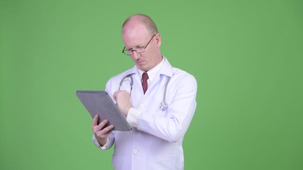 Зрелый лысый врач с помощью цифрового планшета — стоковое видео