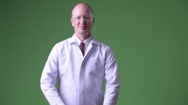 Silah ile koruyucu gözlük takan mutlu olgun kel adam doktor geçti