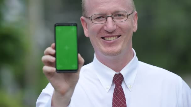 Gelukkig rijpe kale zakenman telefoon buitenshuis weergegeven: — Stockvideo