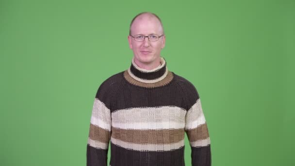 タートルネックのセーターを着てニコニコ幸せな成熟したハゲ男 — ストック動画