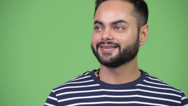 考えながら笑みを浮かべて若い幸せなひげを生やしたインド男 — ストック動画