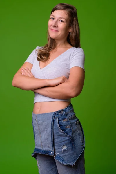 Junge schöne Frau vor grünem Hintergrund — Stockfoto