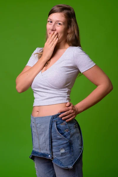 Jovem mulher bonita contra fundo verde — Fotografia de Stock