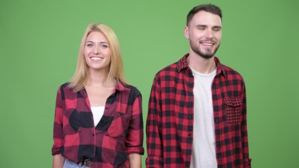 Молода щаслива пара посміхається і повертається з сумними обличчями разом — стокове відео