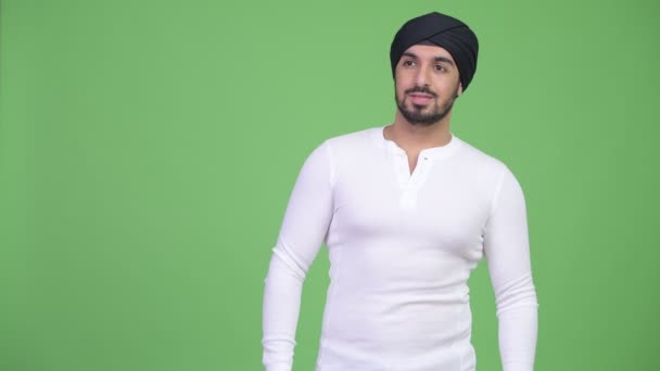 Ung glad skäggig indisk man med turban tänkande — Stockvideo