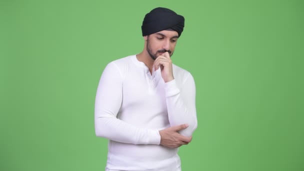 Súlyos szakállas indiai fiatalember gondolkodás közben nézett le — Stock videók