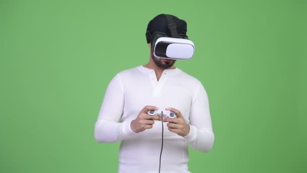 Jeune homme indien barbu jouer à des jeux tout en utilisant un casque de réalité virtuelle — Video