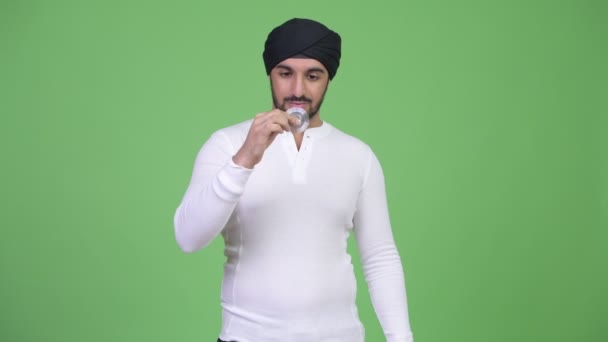 Young handsome bearded Indian man playing with fidget spinner — Stock Video