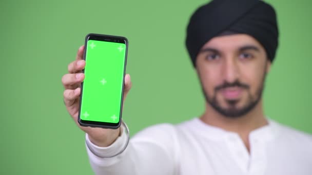 Ung glad skäggig indisk man visar telefonen — Stockvideo
