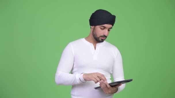 Fiatal hangsúlyozta, szakállas indiai ember használ digitális tábla és szerzés a rossz hír — Stock videók