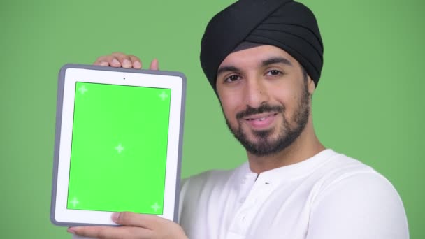 Jeune homme indien barbu heureux montrant et regardant tablette numérique — Video