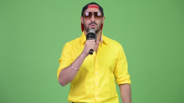 Бородатий молодий індійський бізнесмен, співати з мікрофоном — стокове відео