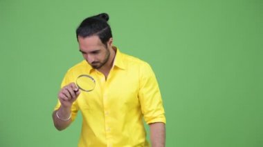 Genç Hintli işadamı büyüteç ile oynarken sakallı