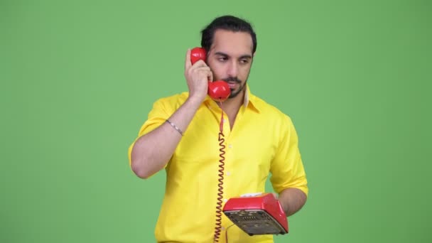 Young angry bearded Indian businessman shouting at the phone — Stock Video