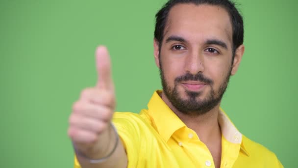 Giovane uomo d'affari indiano barbuto felice pensando mentre dà pollici in su — Video Stock