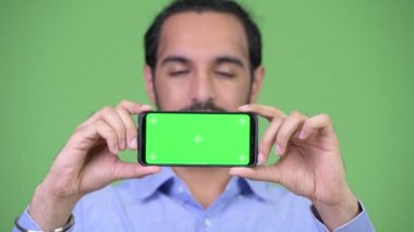 Mutlu genç Hintli işadamı gösteren telefon sakallı