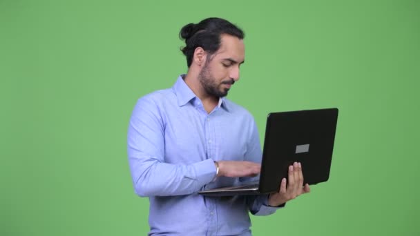 Profil bild av ung glad skäggig indisk affärsman med laptop — Stockvideo