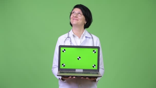 Hermosa mujer médico con pelo corto mostrando portátil — Vídeos de Stock