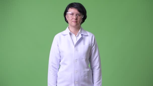 Happy beautiful woman doctor wearing protective glasses with arms crossed — Stock Video