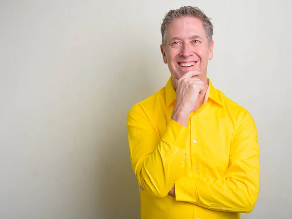 Retrato de empresário maduro vestindo camisa amarela — Fotografia de Stock