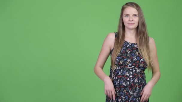 Junge glückliche schwangere Frau zeigt etwas — Stockvideo