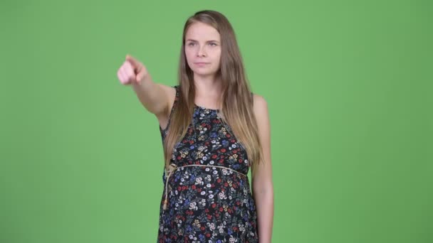 Молода красива вагітна жінка думає, вказуючи пальцем — стокове відео