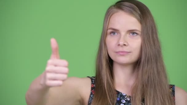 Young happy beautiful woman thinking and giving thumbs up — Stock Video