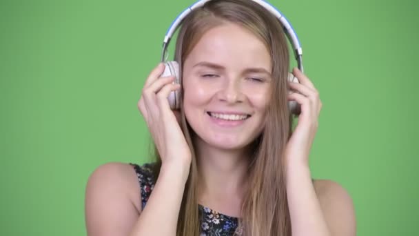 Jovem mulher bonita feliz ouvindo música — Vídeo de Stock