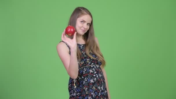 Joven hermosa embarazada lanzando manzana en el aire — Vídeos de Stock
