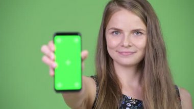 Genç mutlu güzel kadın gösteren telefon