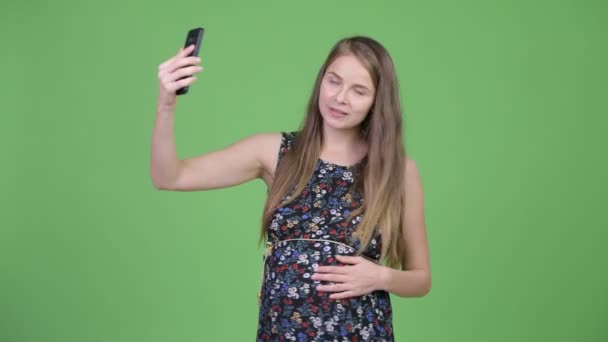 Jovem feliz mulher grávida vídeo chamando e mostrando telefone — Vídeo de Stock