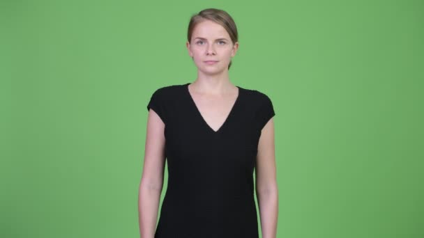 Jonge mooie zakenvrouw tegen groene achtergrond — Stockvideo