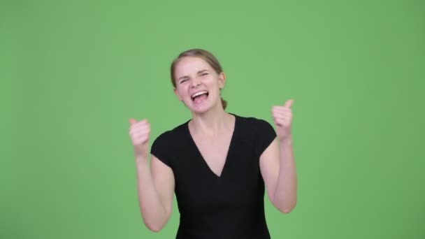 Young happy beautiful businesswoman looking excited and giving thumbs up — Stock Video