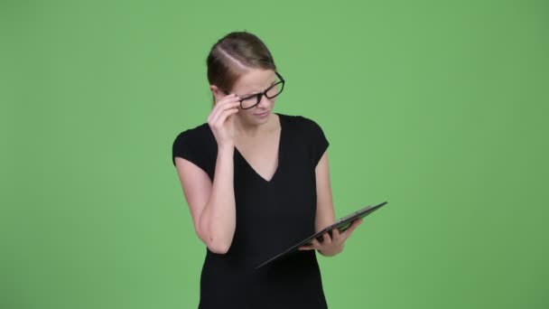Junge glückliche schöne Geschäftsfrau liest auf Klemmbrett und bekommt gute Nachrichten — Stockvideo