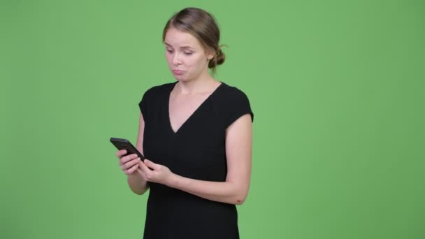 Unga glada vacker affärskvinna tänkande medan du använder telefonen — Stockvideo