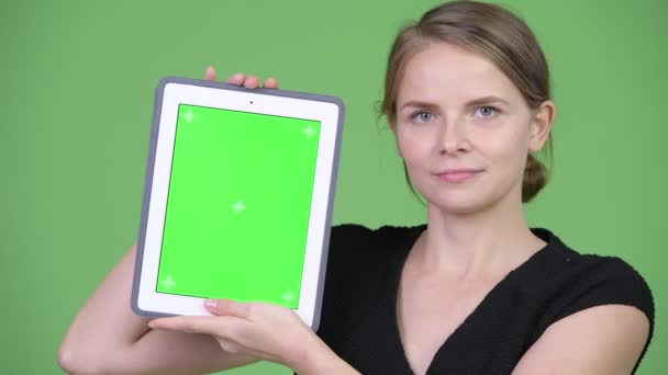 Junge glückliche Geschäftsfrau zeigt digitales Tablet — Stockvideo